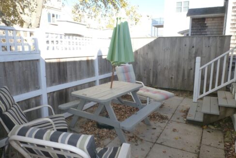 a patio with a table and chairs and an umbrella.