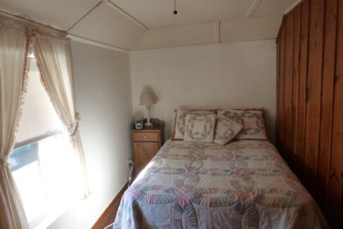 a bed sitting in a bedroom next to a window.