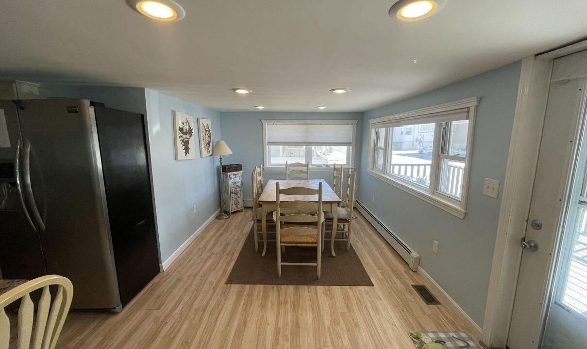 a kitchen with a table and chairs and a refrigerator.