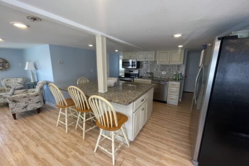 a kitchen and living room with a refrigerator.