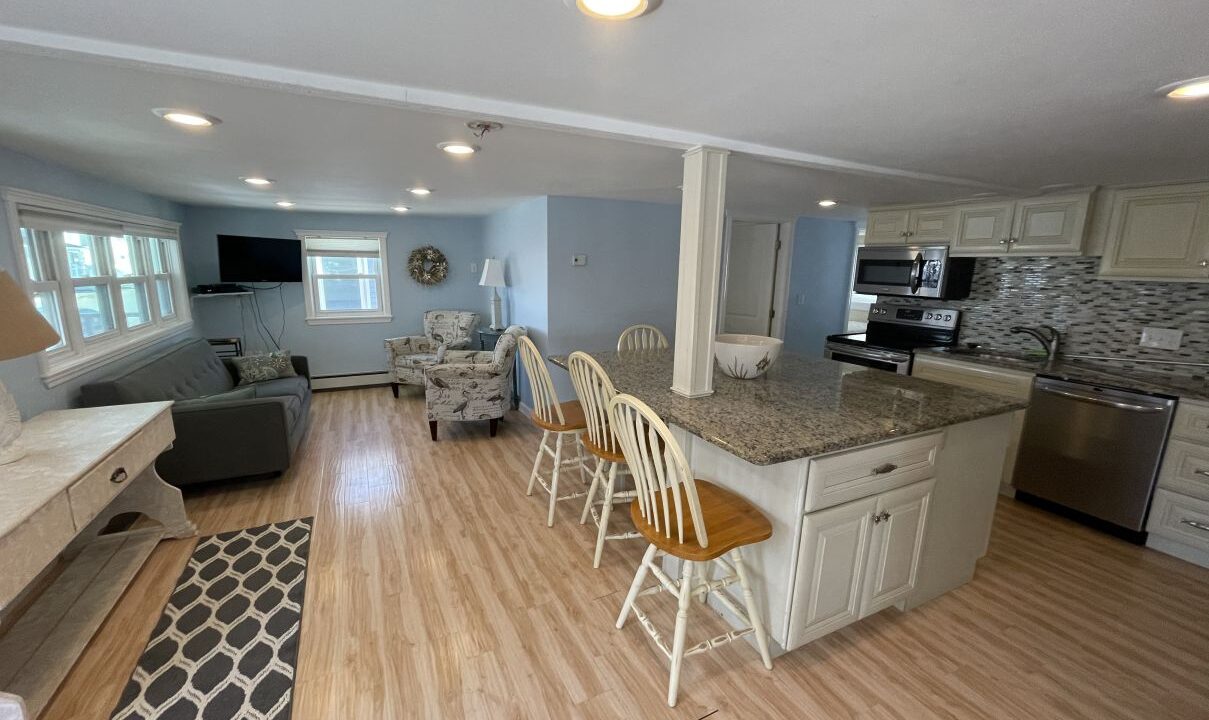 a kitchen and living room with hardwood floors.