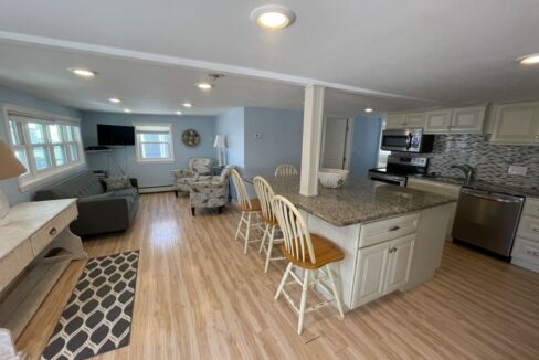 a kitchen and living room with hardwood floors.