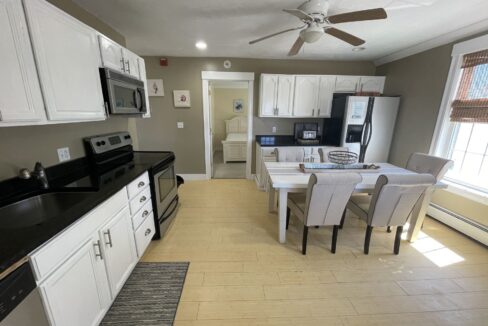 a kitchen with white cabinets and black counter tops.