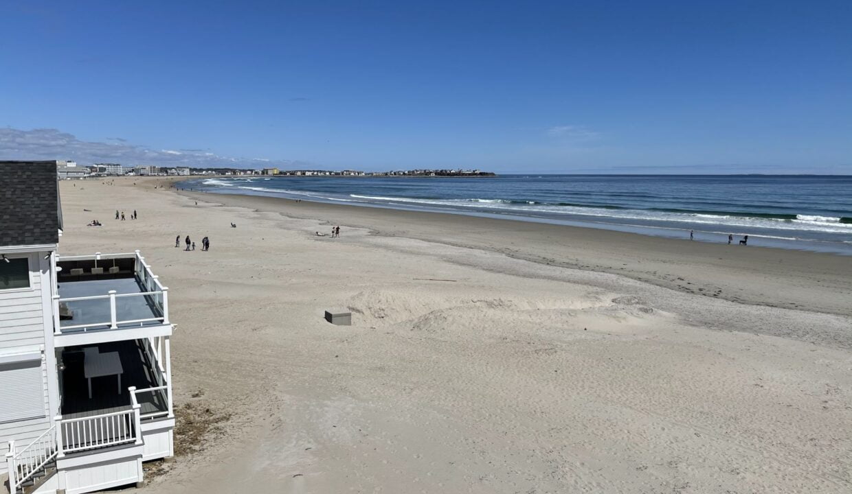 a view of a beach with people walking on it.