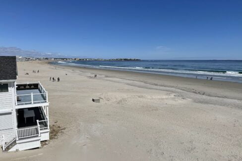 a view of a beach with people walking on it.