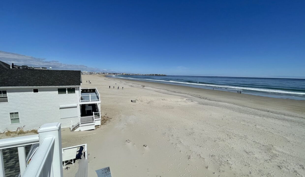 a view of a beach from a balcony of a house.