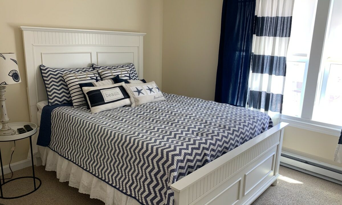 a bed with a blue and white comforter in a bedroom.