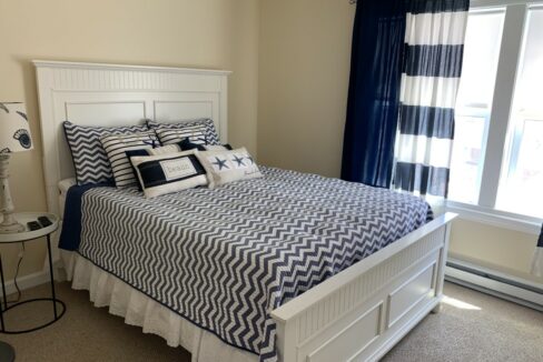 a bed with a blue and white comforter in a bedroom.