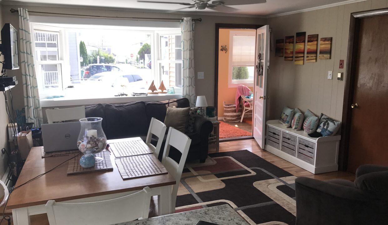 a living room filled with furniture and a laptop computer.