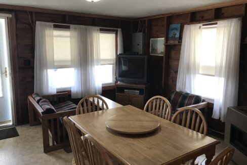 a dining room table with chairs and a television.