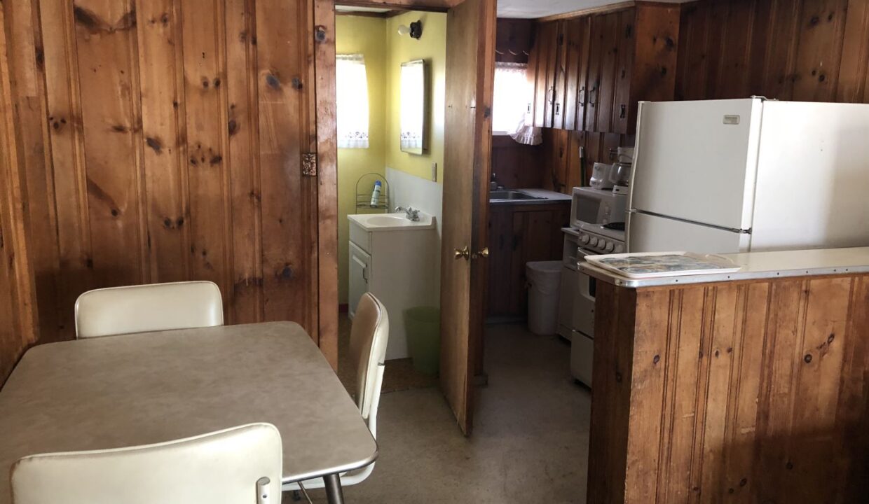 a kitchen with a table and a refrigerator.