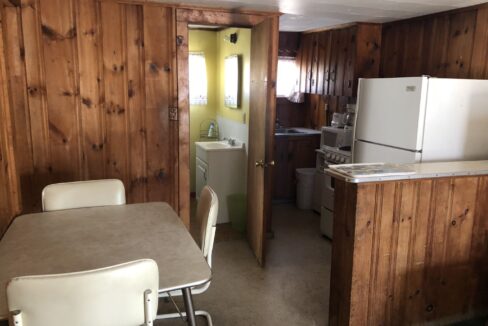 a kitchen with a table and a refrigerator.