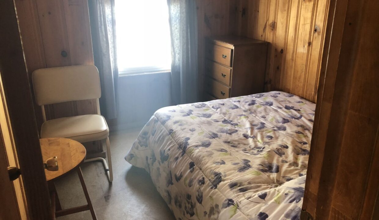 a bed sitting in a bedroom next to a window.