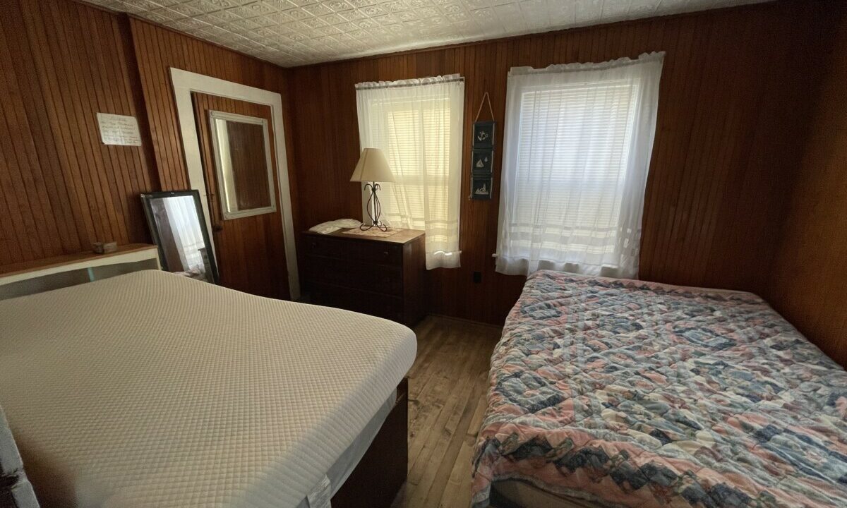 a bed sitting in a bedroom next to a window.