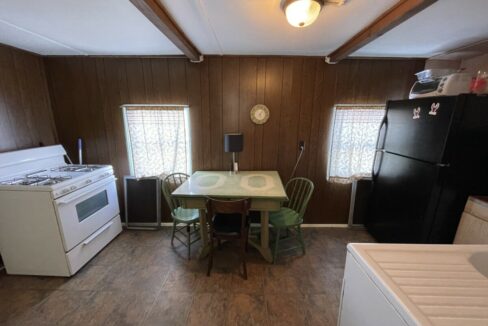 a kitchen with a table, stove and refrigerator.