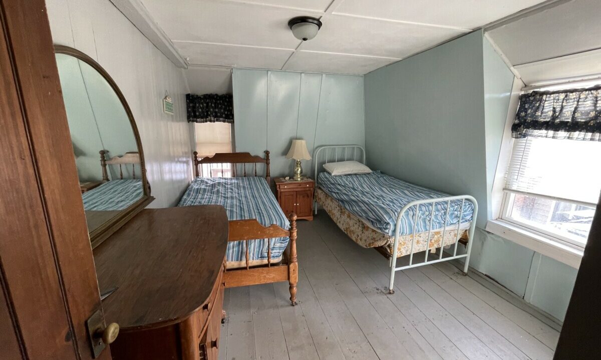 a bedroom with two beds and a dresser.