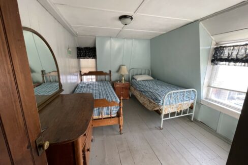 a bedroom with two beds and a dresser.