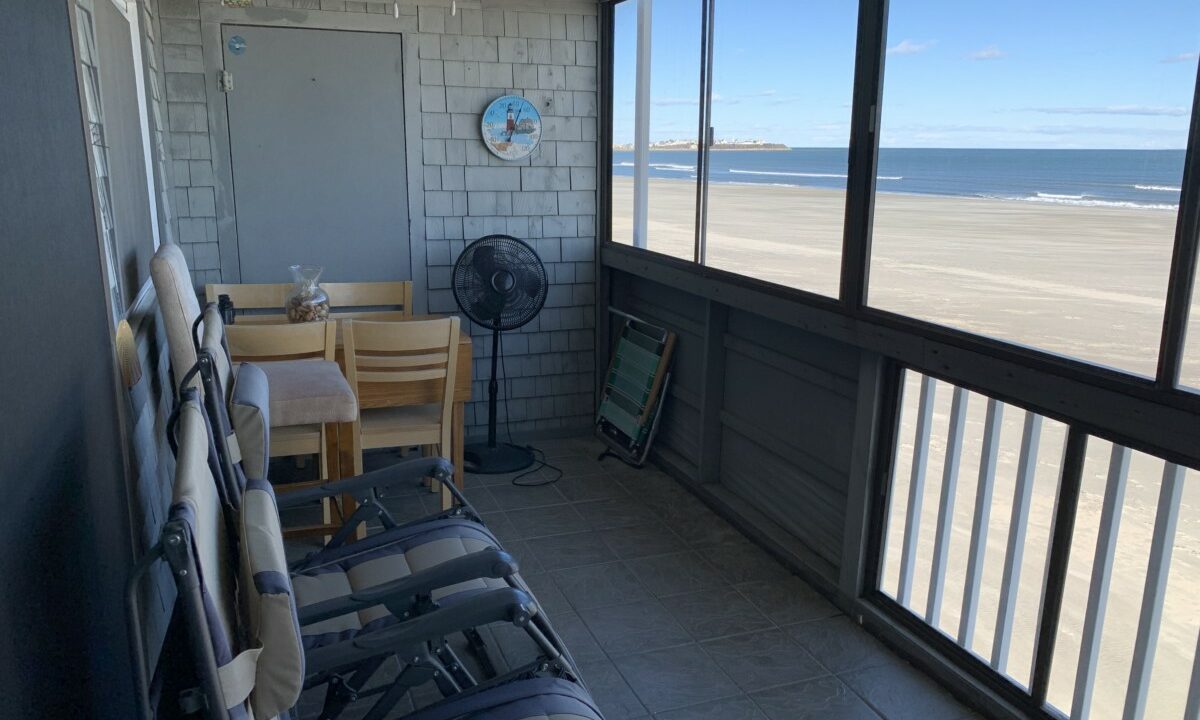 a room with a view of the beach and the ocean.