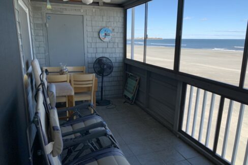 a room with a view of the beach and the ocean.