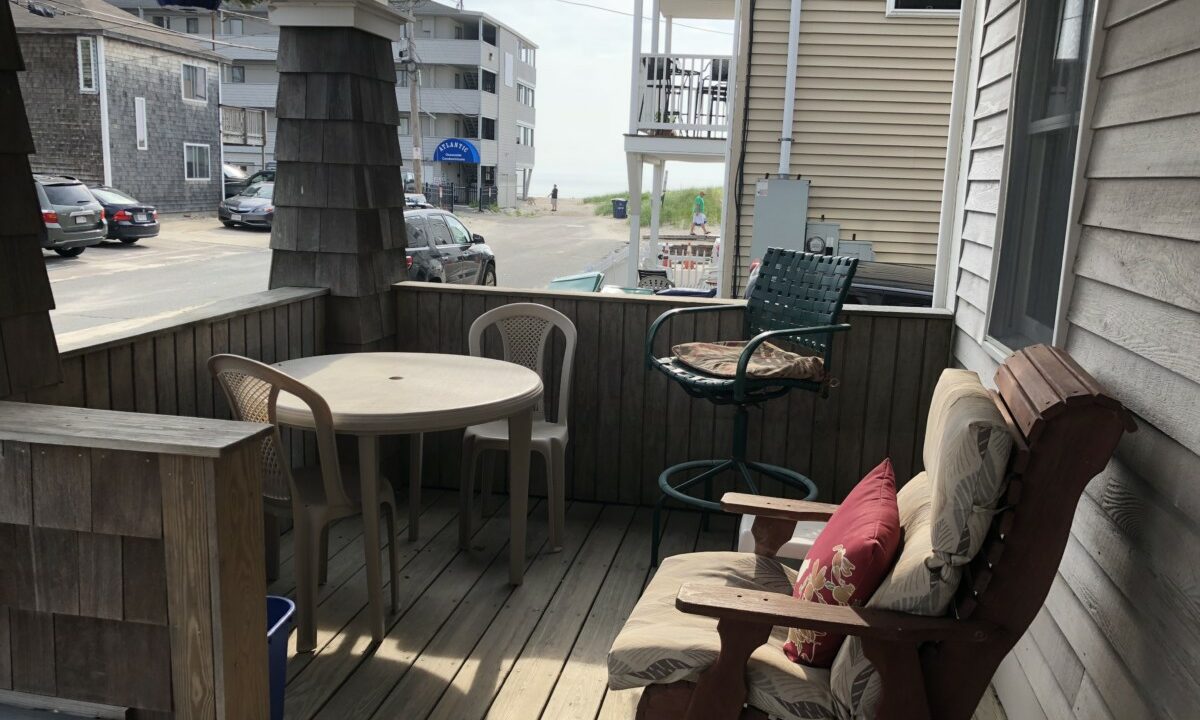 a porch with a table and chairs on it.