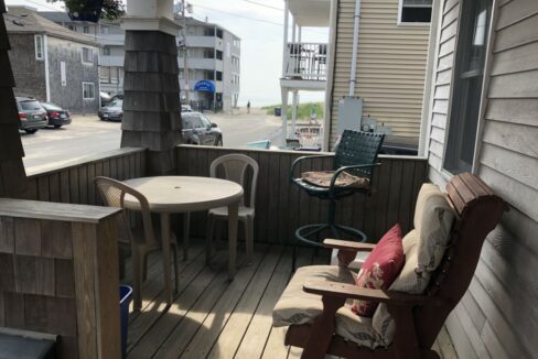 a porch with a table and chairs on it.