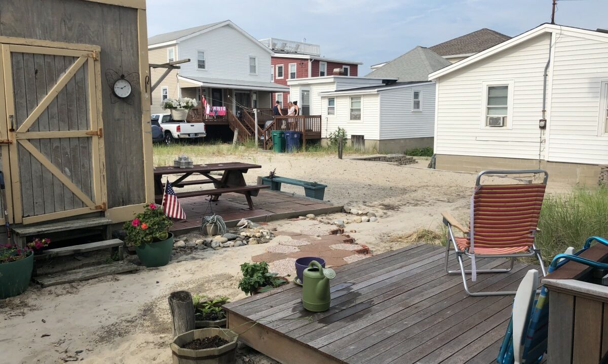 a backyard area with a picnic table and lawn chairs.