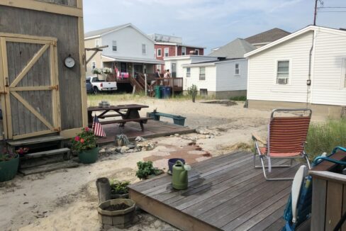 a backyard area with a picnic table and lawn chairs.