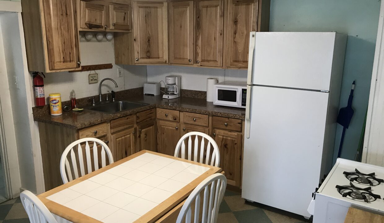 a kitchen with wooden cabinets and a white refrigerator.