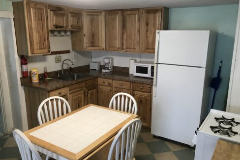 a kitchen with wooden cabinets and a white refrigerator.