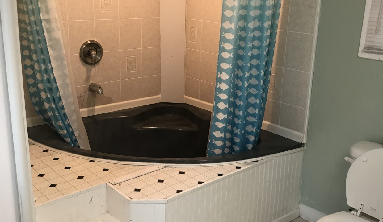 a bath room with a toilet a sink and a bath tub.