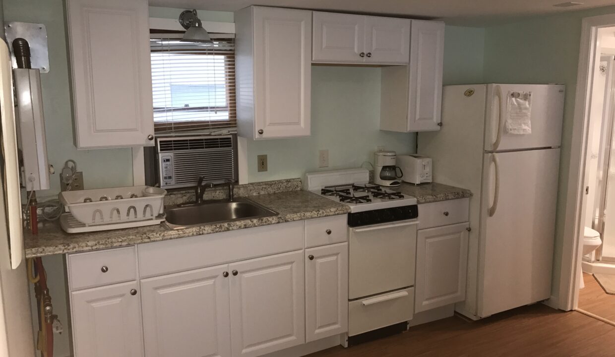 a kitchen with white cabinets and white appliances.
