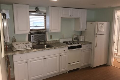 a kitchen with white cabinets and white appliances.