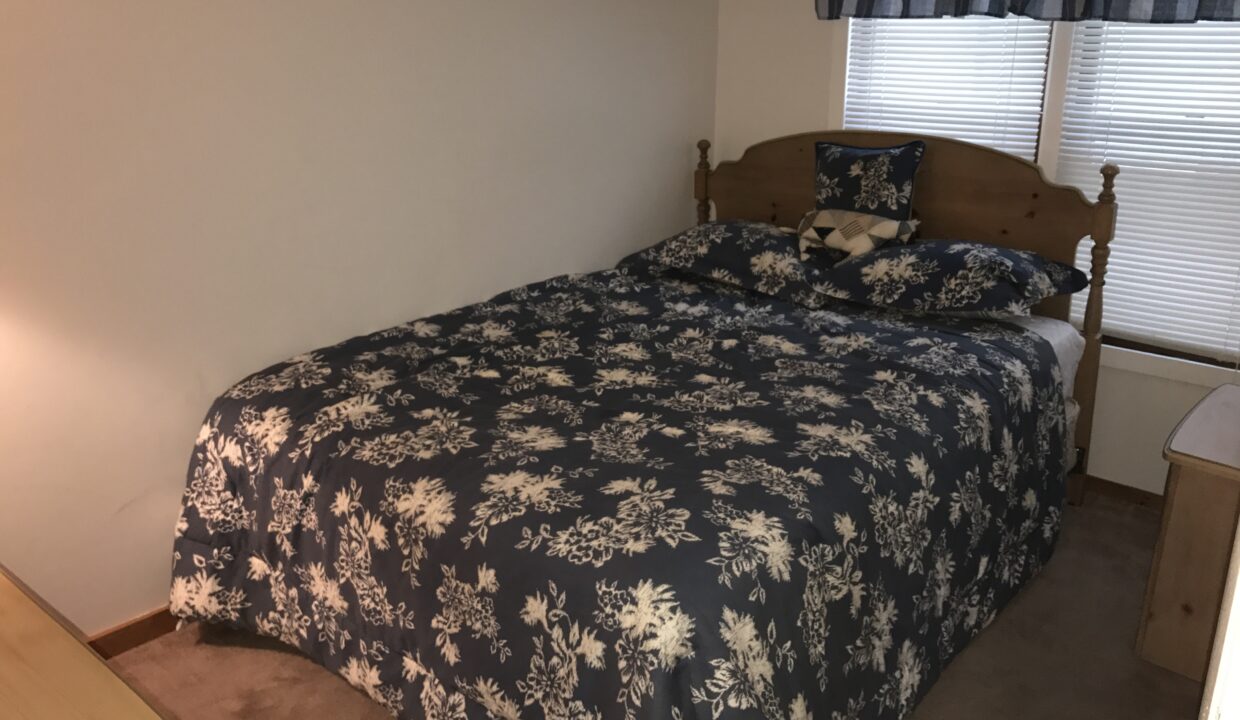 a bed sitting in a bedroom next to a window.