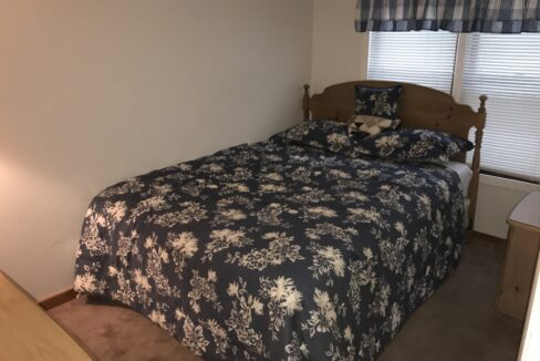 a bed sitting in a bedroom next to a window.