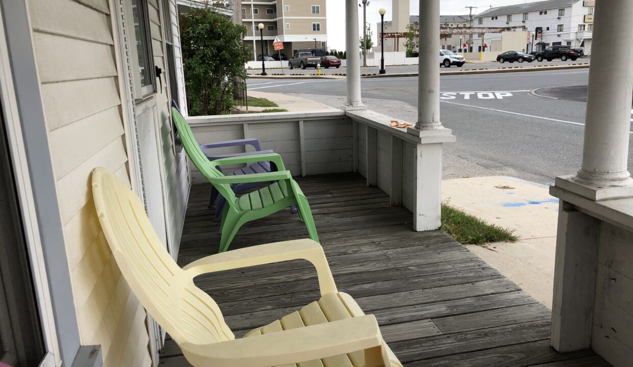 a couple of chairs sitting on top of a wooden porch.