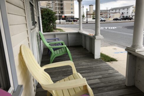 a couple of chairs sitting on top of a wooden porch.