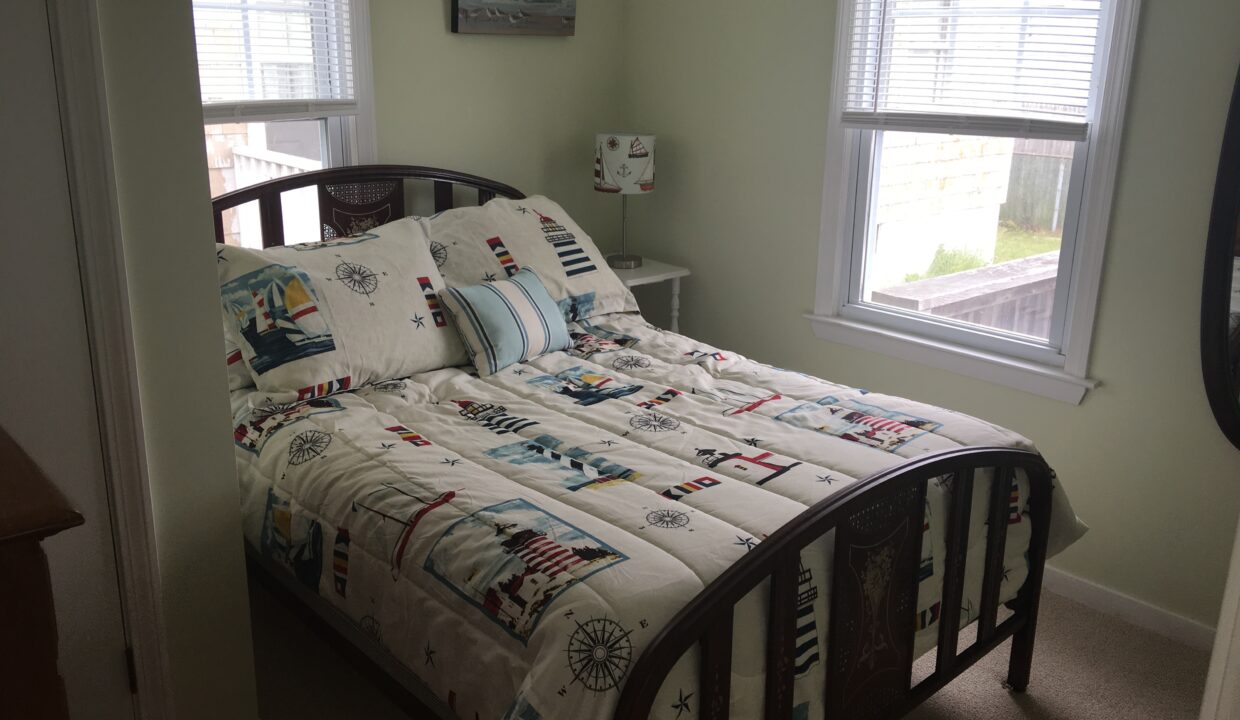 a bed sitting in a bedroom next to two windows.