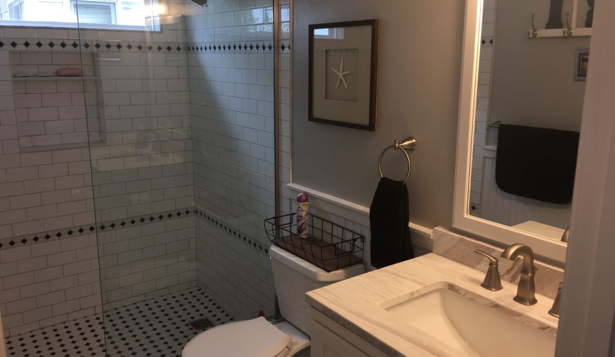 a bathroom with a toilet, sink, and shower.