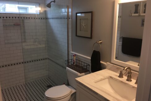 a bathroom with a toilet, sink, and shower.