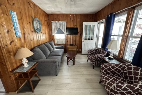 a living room filled with furniture next to a window.