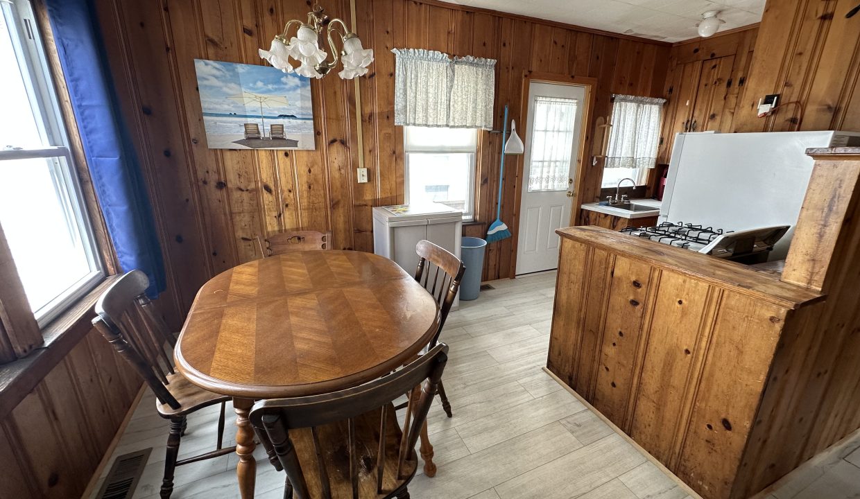 a kitchen with wood paneling and a table and chairs.