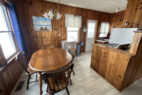 a kitchen with wood paneling and a table and chairs.