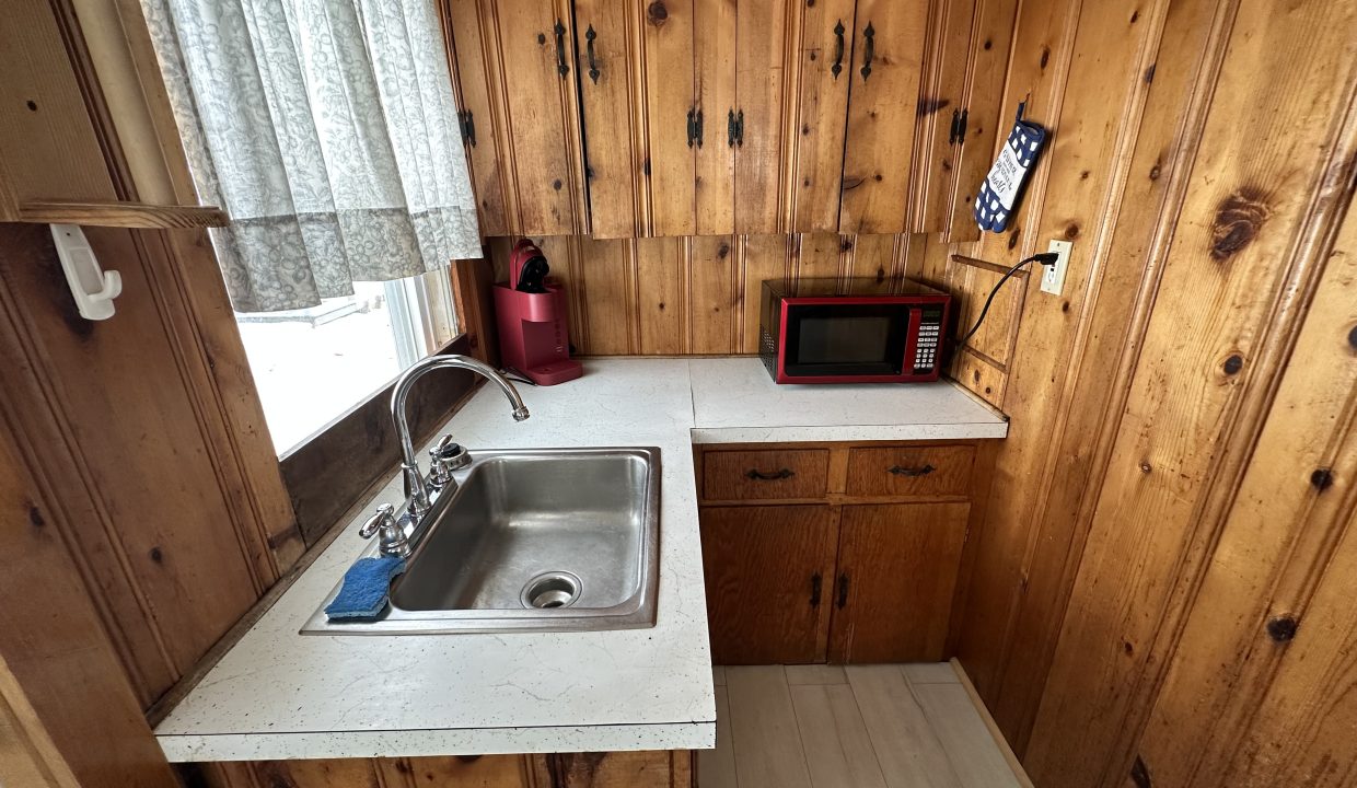 a kitchen with wood paneling and a sink.