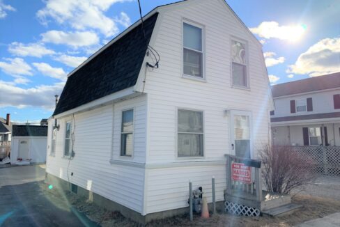 a white two story house with a black roof.