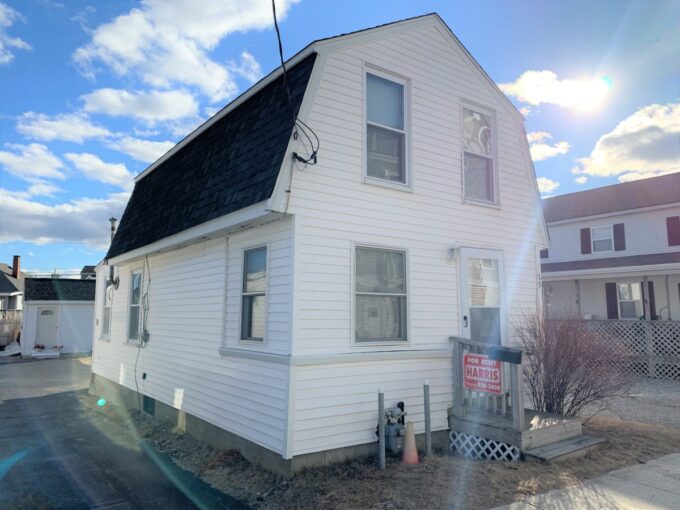 a white two story house with a black roof.