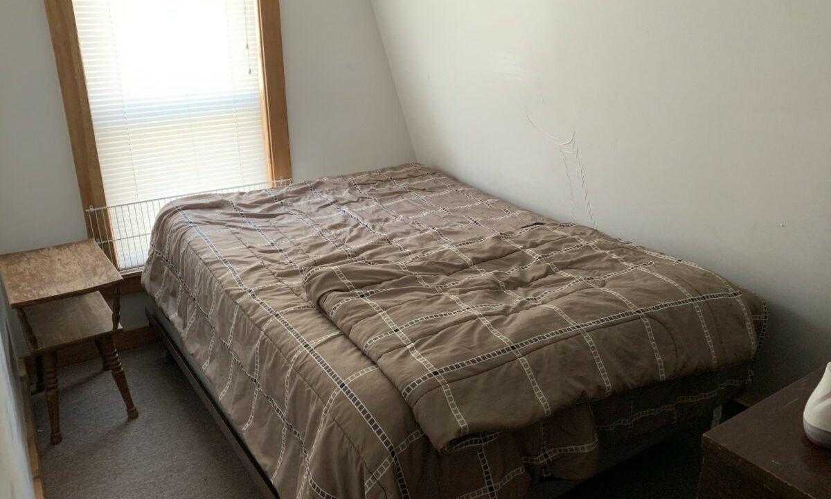 a bed sitting in a bedroom next to a window.