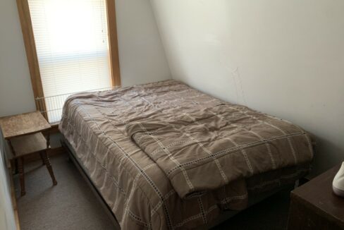 a bed sitting in a bedroom next to a window.