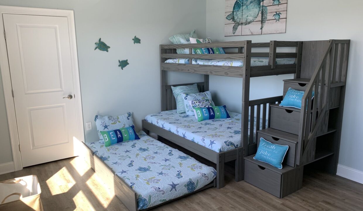 a bedroom with bunk beds and a stair case.