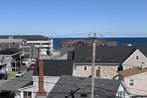 a view of the ocean from a rooftop of a house.
