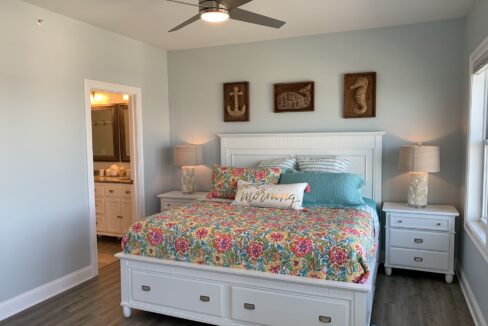 a bedroom with a bed, dressers and a ceiling fan.